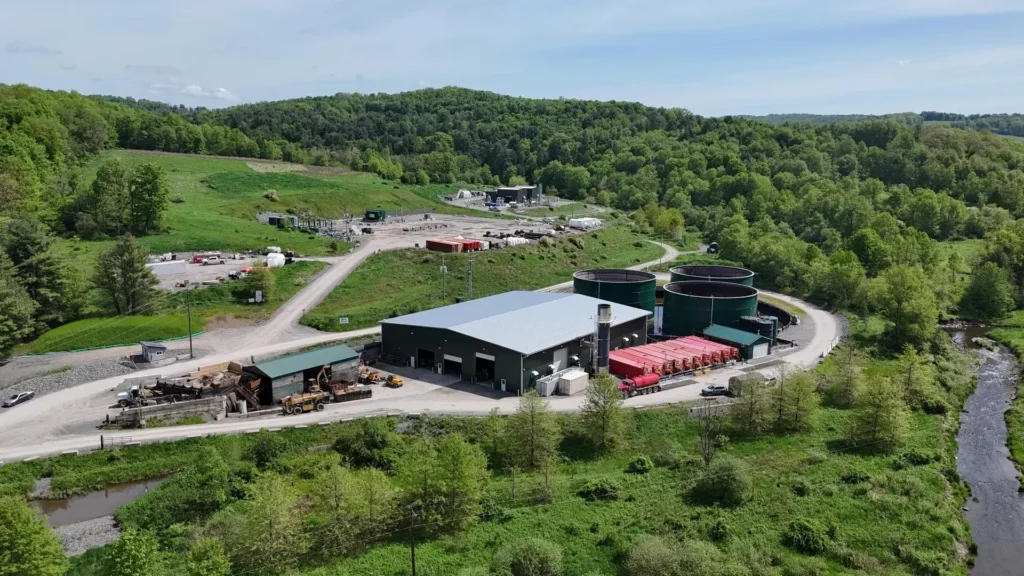 Lithium extraction site with storage tanks, trailers, and forested surroundings in Pennsylvania.